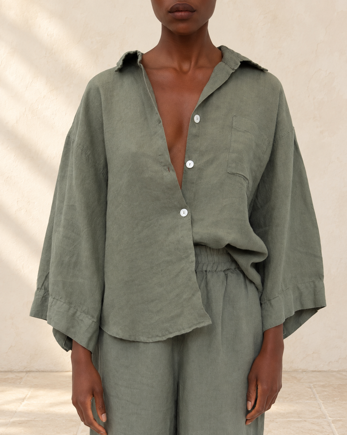 Agnes Linen Top styled against warm ivory plaster and limestone