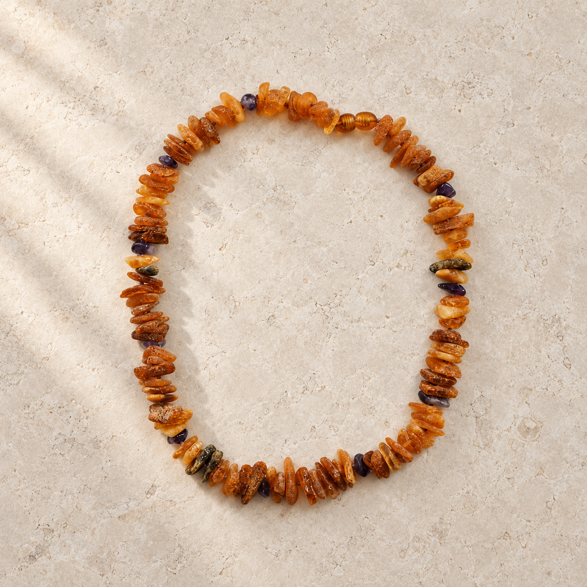 Baltic Amber + Amethyst Pet Necklace styled on a warm ivory and limestone Oak & Row backdrop